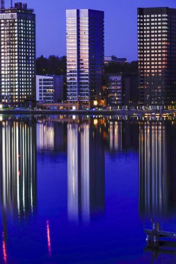 Stockholm, İsveç Liljeholmskajen 'in sularındaki kulelerin yansımaları.