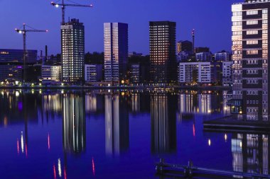 Stockholm, İsveç Liljeholmskajen 'in sularındaki kulelerin yansımaları.
