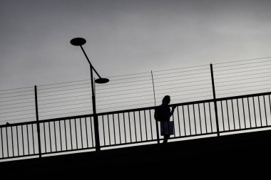 Stockholm, İsveç Batı köprüsünde yürüyen siluetli bir yaya..