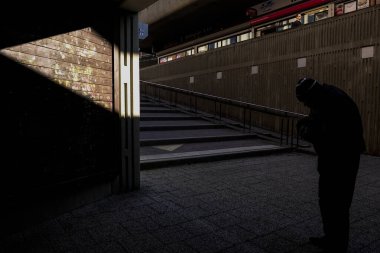 Stockholm, İsveç Bredang banliyösünde bir yaya ve güçlü bir güneş ışığı ve gölge huzmesi.