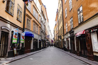 Stockholm, Sweden March 31, 2020 Despite lock downs in all other countries, people in the Swedish capital are still more or less going about their normal business but the streets are noticeably emptier than usual. Pedestrians in the old town clipart