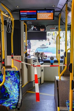 Stockholm, İsveç 31 Mart 2020 'de diğer tüm ülkelerdeki tecrit durumlarına rağmen İsveç başkentindeki insanlar hâlâ normal işlerine devam ediyor ama sokaklar belirgin bir şekilde normalden daha boş. Otobüsler boş ve şoför temiz.