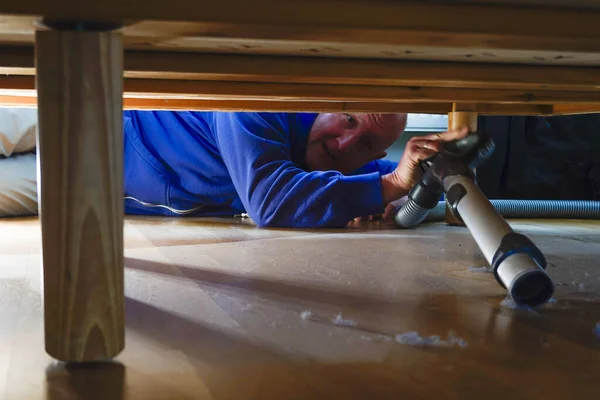 Een Man Stofzuigt Onder Een Bed Een Appartement — Stockfoto