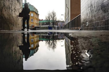 Stockholm, İsveçli yayalar Hronstul civarında ve bir su birikintisi