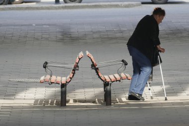 STOCKHOLM, SVEDEN Bastonlu son sınıf bir kadın banktan kalkar.