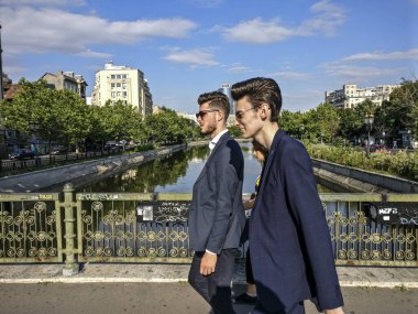 BUCHAREST, ROMANIA Kasabanın merkezinde yürüyen iki şık genç adam.