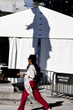 BUCHAREST, ROMANIA Yaya ve Üniversite Meydanı 'ndaki heykelin gölgesi.