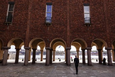 Stockholm, İsveçli insanlar Stockholm Belediyesi veya Stadshuset 'in bahçesinde yürüyorlar..