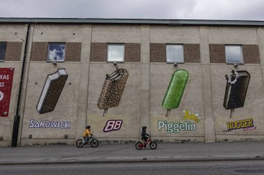 Flen, İsveçli çocuklar ana caddede büyük dondurma üreticisine ait dondurmalarla dekore edilmiş bir duvara biniyorlar..