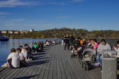 Stockholm, Sweden  People enjoying the outdoors in the Liljeholmskajen neighborhood during the Coronavirus epidemic. clipart