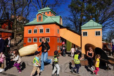 Stockholm, Sweden Children playing a playground in Kvarnholmen during the Corona crisis. The Lilla Kvarnholmen Lekplats or playground is a historical miniature of Kvarnholmen. clipart