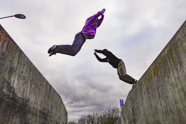 瑞典斯德哥尔摩 尼伯霍夫市 两名年轻人在两个大的混凝土块之间跳着跳着或跳着跳着跳着跳着玩公园舞 — 图库照片