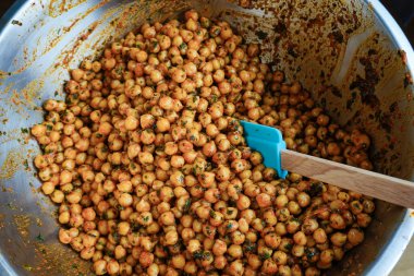Bir spatulayla karıştırmak için baharatlı bezelye ve terbiye..