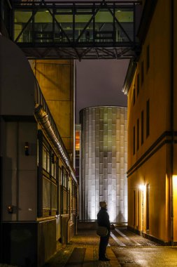 Norrkoping, İsveç Geceleri şehrin eski ve yenilenmiş endüstriyel değirmen bölümünde bir adam duruyor.