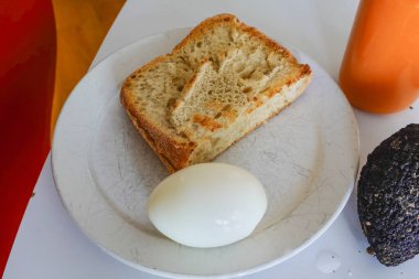 Tost, haşlanmış yumurta ve havuç suyuyla dolu bir tabakta avokado..