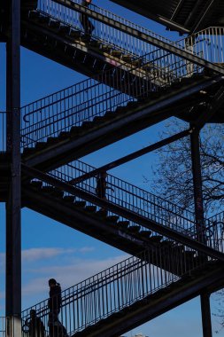 Stockholm, İsveç Liljeholmen köprüsünün altında yürüyen insanlar.