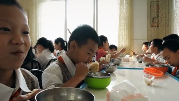 Guangyuan, CHINA - JUNE 04, 2019: Children have breakfast in school canteen, China . — стоковое видео