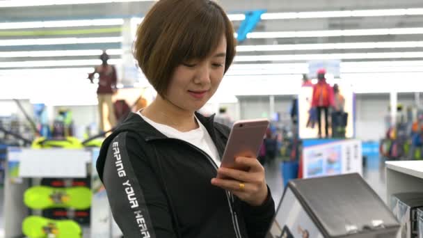 Vrouw met smartphone in de winkel — Stockvideo