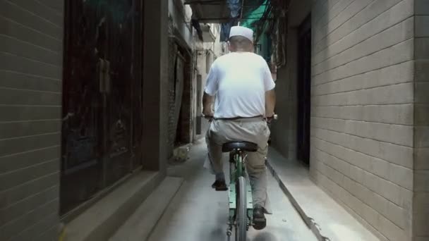 Xian, Shaanxi, China, 13 de junio de 2019. Bicicletas hombre en un callejón estrecho — Vídeo de stock