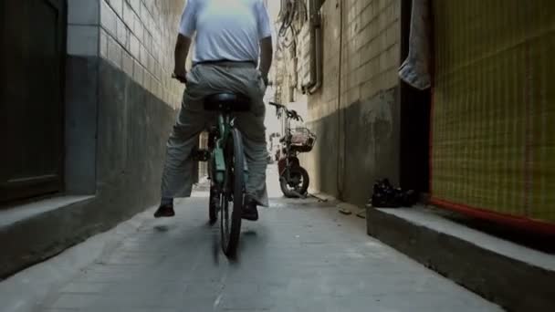 Xian, Shaanxi, China, JUNE 13, 2019. Man ride bicycles in a narrow alley — Stock Video