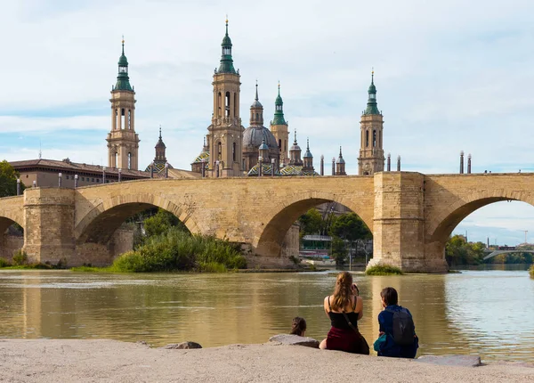 Turistas tomando fotos a la Basílica de Nuestra Señora del Pilar y al Puente de Piedra en Zaragoza, España — Foto de Stock