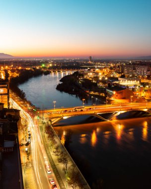 İspanya 'nın Zaragoza kentindeki Bazilika del Pilar kulesinden Ebro nehrinin hava günbatımı manzarası