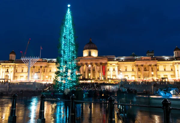 London, uk / europa; 20 / 12 / 2019: Nachtansicht der Nationalgalerie und ein Weihnachtsbaum am Trafalgar Square, London. Langzeitbelichtungsaufnahme mit unscharfen Personen beim Gehen. — Stockfoto