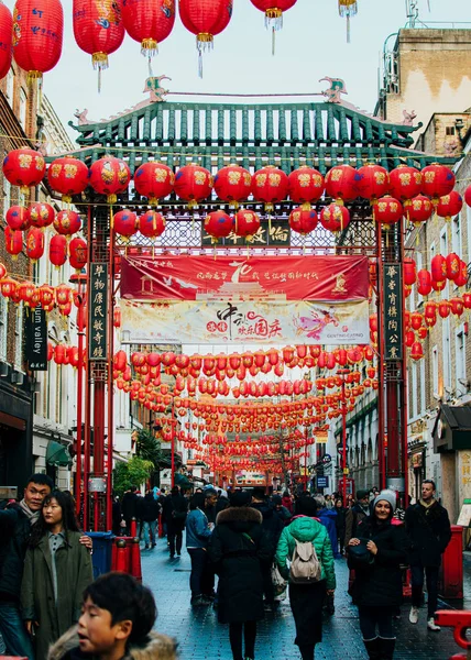 London, UK / Europe; 20 / 12 / 2019: Chinese gate and red lanterns in Chinatown in the district of Soho, London. Люди ходят и делают покупки на улице . — стоковое фото