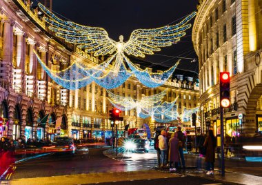 Londra, Uk / Avrupa; 21 / 12 / 2019: Regent Caddesi 'nde Noel süsü olarak parlak melekler. Araba izleri ve bulanık insanlarla uzun pozlar..