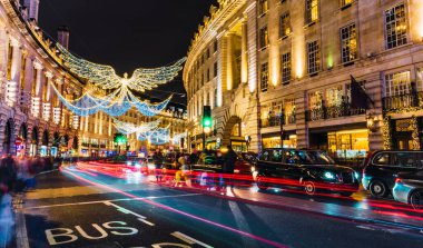 Londra, Uk / Avrupa; 21 / 12 / 2019: Regent Caddesi 'nde Noel süsü olarak parlak melekler. Araba izleri ve bulanık insanlarla uzun pozlar..