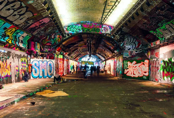London, Storbritannien / Europa; 2019-12-21: Leake Street, underjordisk tunnel med graffiti täckta väggar i London. Scen med fotgängare och graffitimålare. — Stockfoto