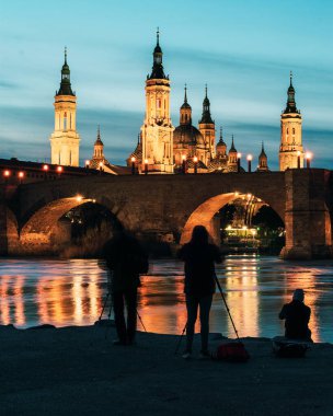 Photographers in front of Basilica del Pilar and Puente de Piedra at sunset in Zaragoza, Aragon, Spain