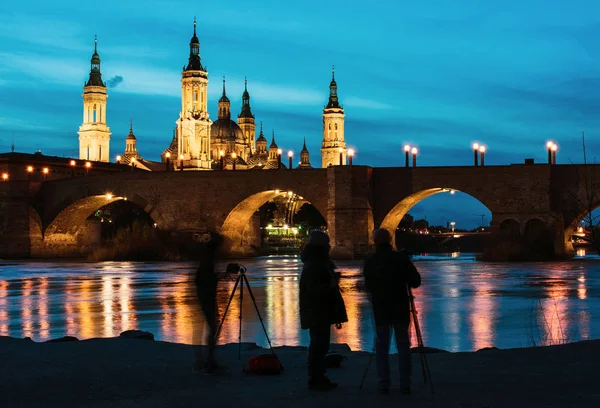 Photographers in front of Basilica del Pilar and Puente de Piedra at sunset in Zaragoza, Aragon, Spain