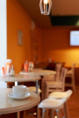 Kahve fincanı, bulanık arka planı, beyaz çay fincanı, kahvaltı, kafeterya portakalı olan bir kafede masanın üstünde.