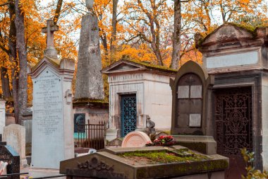 Paris, Fransa - 14 Kasım 2019: Fransa 'nın en ünlü Paris Pere Lachaise mezarlığının sonbahar sokağı manzarası. Çeşitli ünlü insanların mezarları. En eski mezarların üzerinde altın sonbahar.
