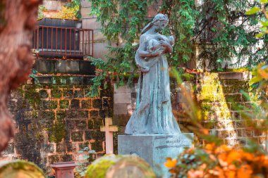 Paris, Fransa - 14 Kasım 2019: Paris Pere Lachaise, Fransa 'nın en ünlü mezarlığındaki eski taş kadın anıtı. Çeşitli ünlü insanların mezarları. En eski mezarların üzerinde altın sonbahar.