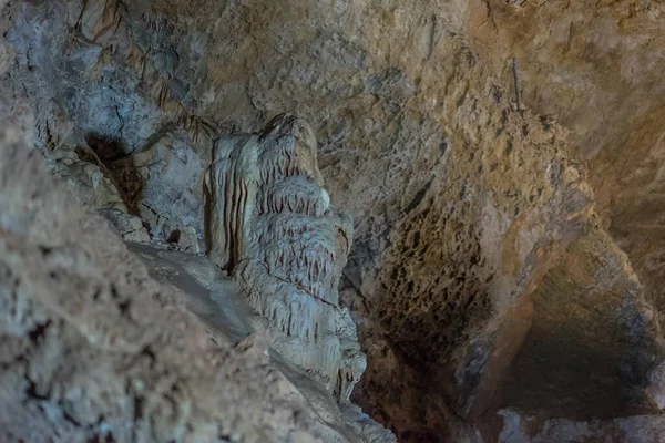 Under the ground. Beautiful view of stalactites and stalagmites in an underground cavern - New Athos Cave. Sacred ancient underworld formations