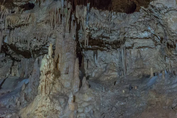 Under the ground. Beautiful view of stalactites and stalagmites in an underground cavern - New Athos Cave. Sacred ancient underworld formations