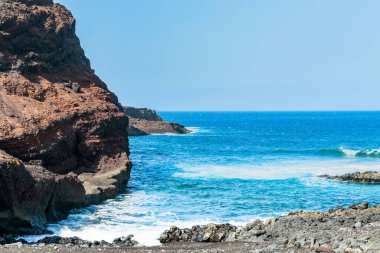Tenerife, Teno Burnu yakınlarındaki okyanus kayalıkları. Parlak ve parlak mavi deniz dalgalı Vulkanik kayalar. Kanarya adalarında güneşli bir gün