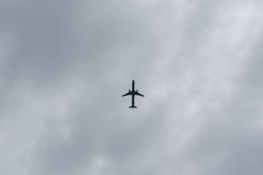 Uçak iniyor. Bulutlu gökyüzü, alt görünüm