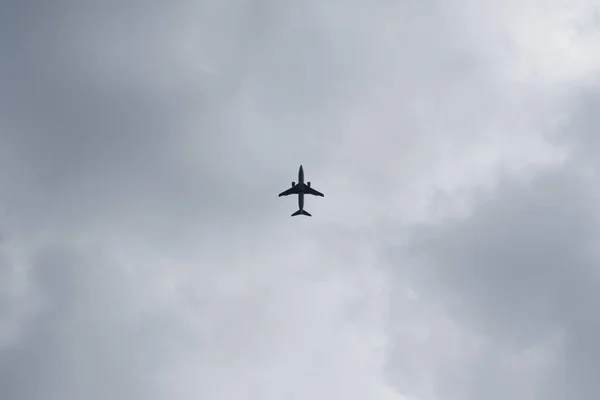 O avião está a aterrar. Céu nublado, vista de baixo — Fotografia de Stock