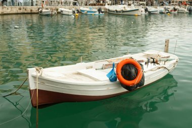 Kayık rıhtımda duruyor, küçük bir balık sürüsü nea 'da yüzüyor.