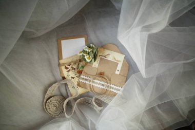 Düğün aksesuarları: papatya düğmesi, zarf, davetiye