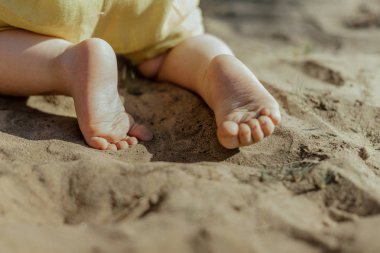 Küçük bir çocuk kumda sürünüyor..