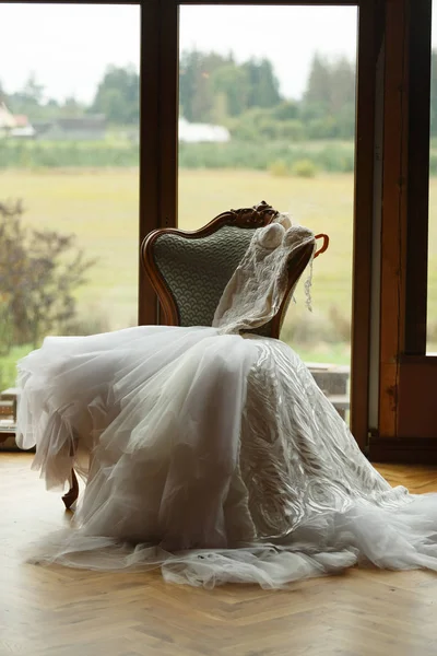 Bröllopsklänningen ligger på fåtöljen, i bakgrunden en larv — Stockfoto