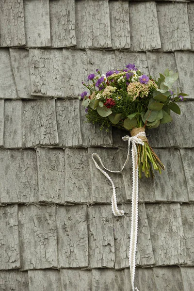 Brudarnas bröllopsbukett ligger på trätakpannorna i huset — Stockfoto