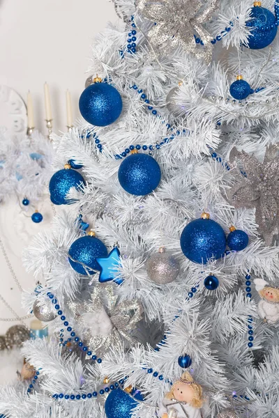 Blue and silver Christmas balls and stars on the branches of a w