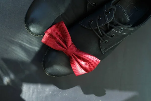 red tie butterfly lies on shoes