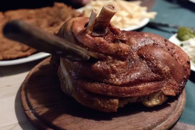 Fırında domuz eti, ahşap tezgahta kemikli bıçak. Yukarıdan görüntüle