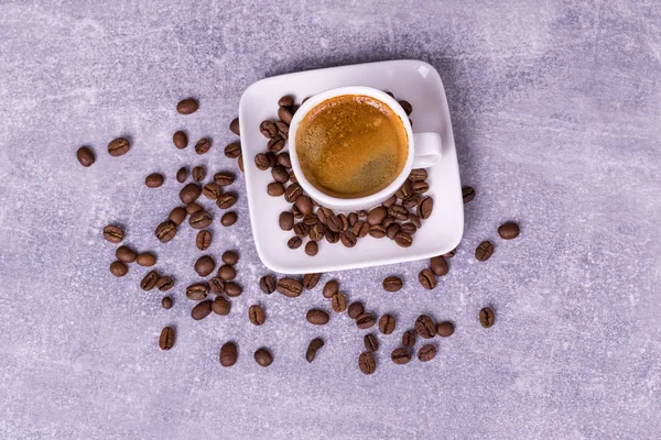 Café caliente en una taza, granos de café están dispersos cerca. Ver fro — Foto de Stock